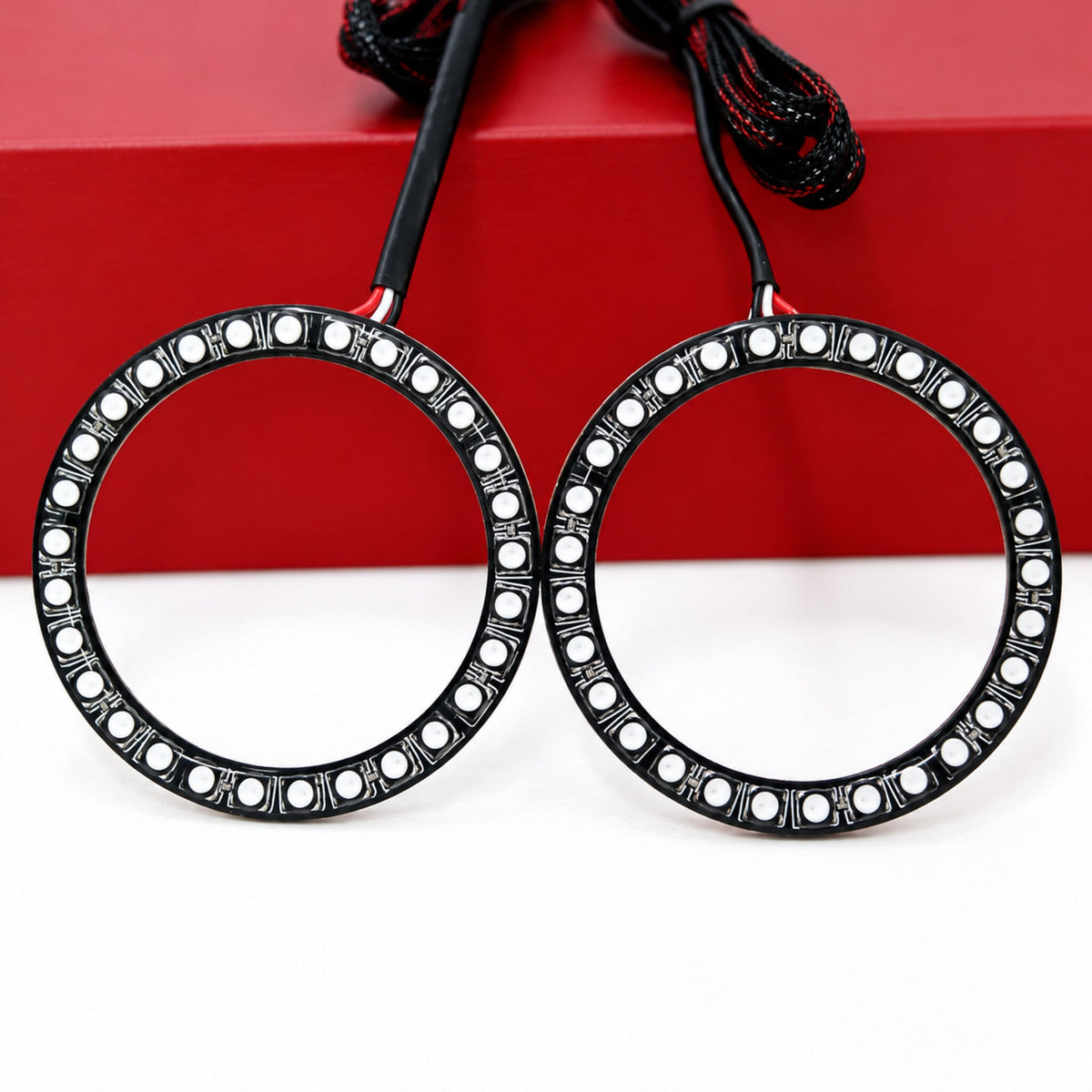 Two unlit LED halo rings with black circuit boards and wiring
