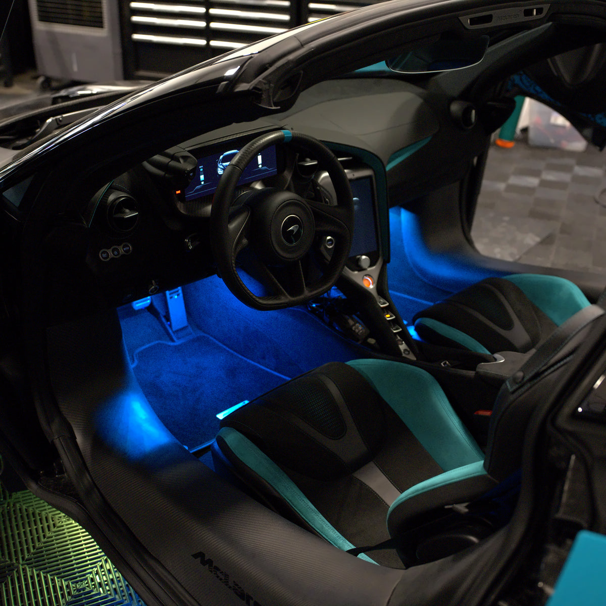 Blue footwell lighting installed in the McLaren, viewed through the open driver door