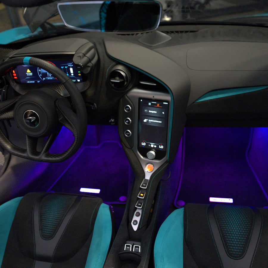 Purple footwell lighting in the blue McLaren, showing the driver and passenger footwells