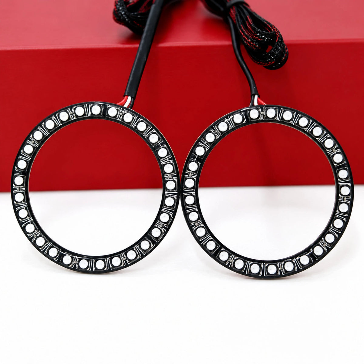 Two unlit LED halo rings with black circuit boards and wiring